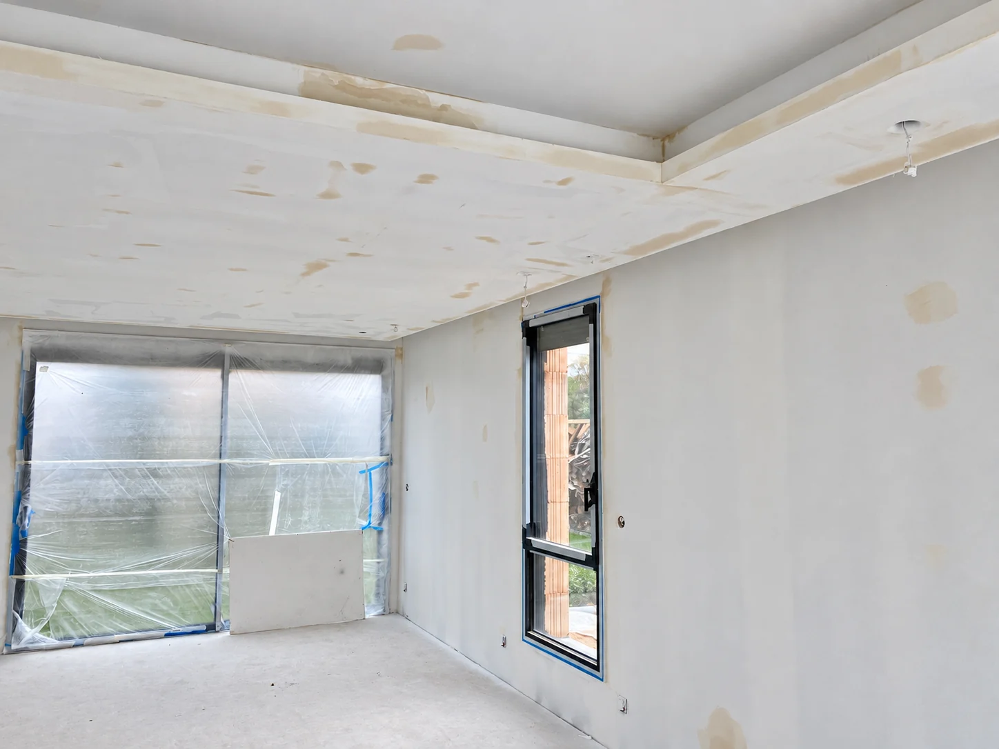 Cloison avec trois niches éclairées sous une mezzanine dans un séjour.